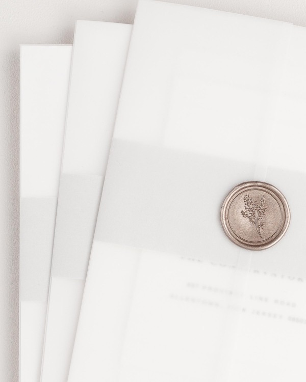 Sophia wedding invitation with a soft gray belly band, translucent vellum jacket, and bronze posy wax seal.