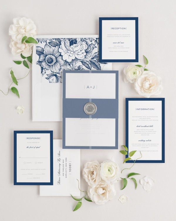 Sophisticated Modern wedding invitations flat lay with navy garden rose liner, navy belly band, translucent vellum jacket, and silver florette wax seal.