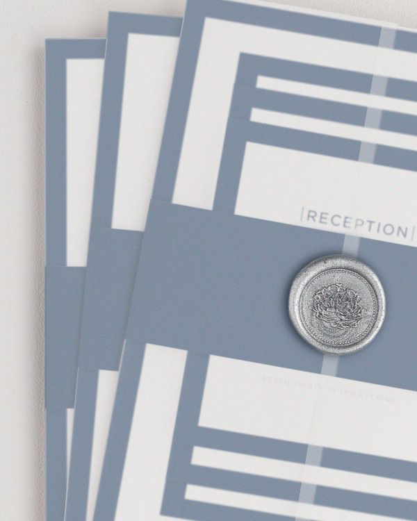 Sophisticated Modern wedding invitation with a navy belly band, translucent vellum jacket, and silver florette wax seal.