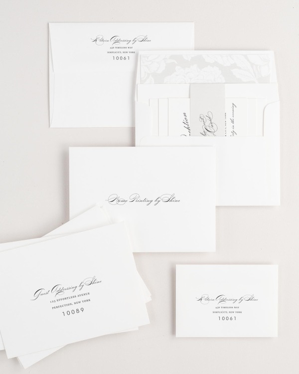 Vintage Glam wedding invitation envelopes with guest addressing, return addressing, and name printing services. Inner envelope features a blooms liner and soft gray belly band.