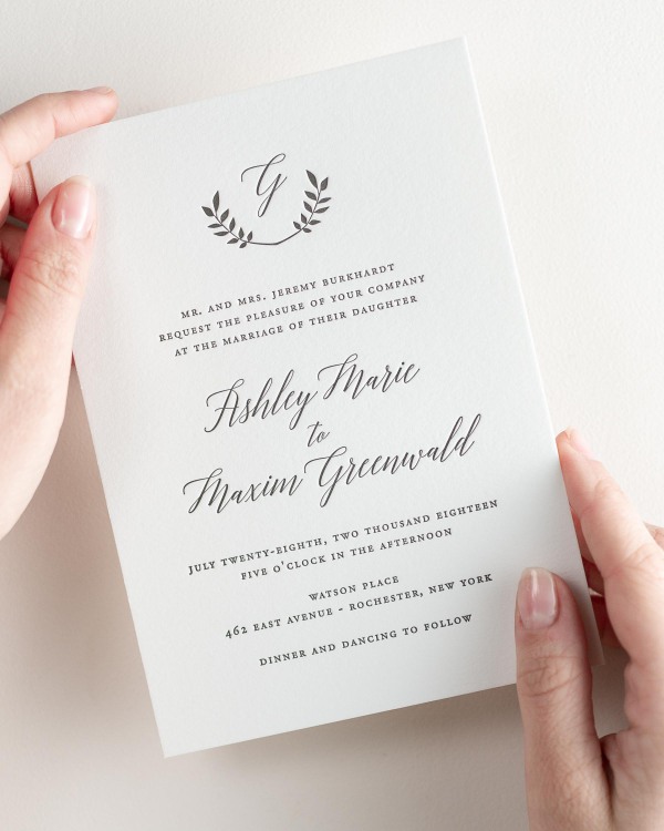Bride holding her 5x7” Wreath Monogram letterpress wedding invitation.