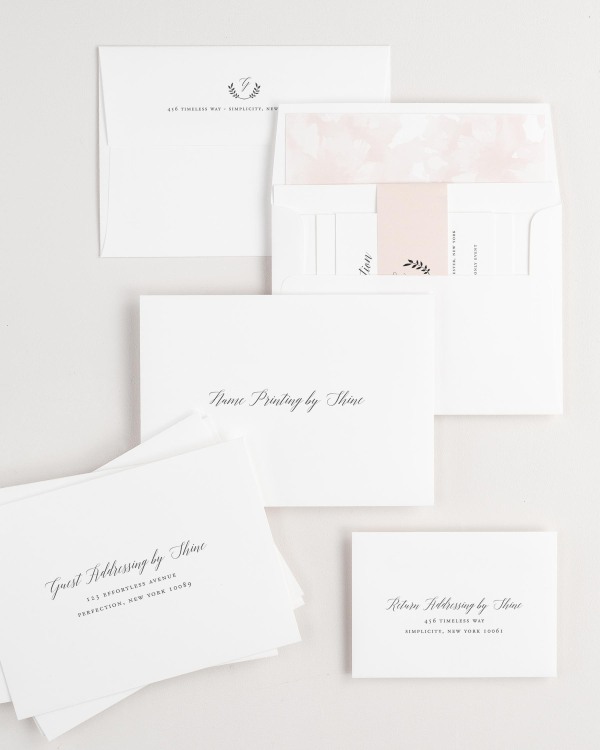 Wreath Monogram wedding invitation envelopes with guest addressing, return addressing, and name printing services. Inner envelope features a watercolor peonies liner and rose gold belly band.