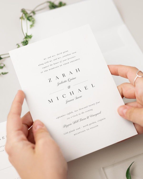 Bride holding her Zarah wedding invitation.