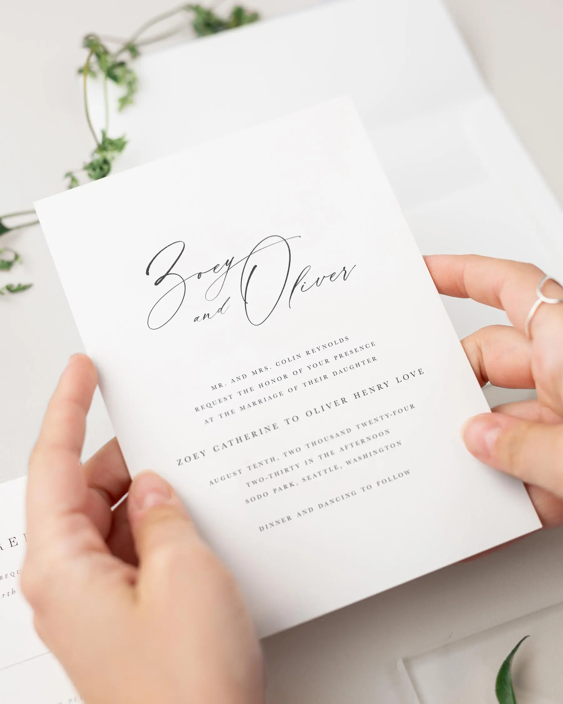 Bride holding her Zoey wedding invitation.