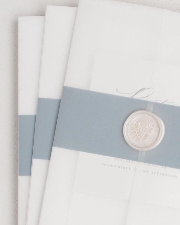 Zoey wedding invitation with a mineral belly band, translucent vellum jacket, and pearl wreath wax seal.